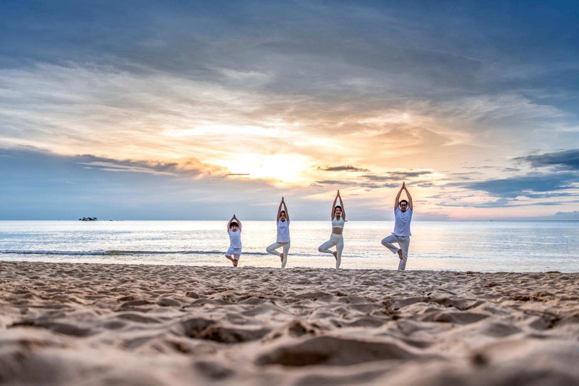Vinpearl Wonderworld Phu Quoc Hotel Exterior photo Family practicing yoga on the beach